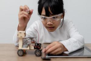 Asia students learn at home in coding robot cars and electronic board cables in STEM, STEAM, mathematics engineering science technology computer code in robotics for kids concept. photo