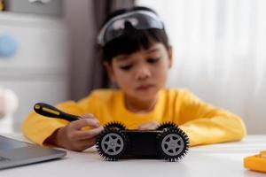 los estudiantes de asia aprenden en casa a codificar autos robot y cables de tableros electrónicos en tallo, vapor, ingeniería matemática, ciencia, tecnología, código de computadora en robótica para el concepto de niños. foto