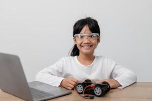 Asia students learn at home in coding robot cars and electronic board cables in STEM, STEAM, mathematics engineering science technology computer code in robotics for kids concept. photo