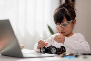 Asia students learn at home in coding robot cars and electronic board cables in STEM, STEAM, mathematics engineering science technology computer code in robotics for kids concept. photo