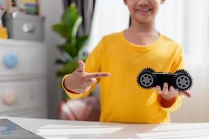 Asia students learn at home in coding robot cars and electronic board cables in STEM, STEAM, mathematics engineering science technology computer code in robotics for kids concept. photo