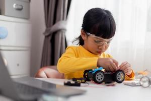 Asia students learn at home in coding robot cars and electronic board cables in STEM, STEAM, mathematics engineering science technology computer code in robotics for kids concept. photo