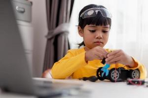 Asia students learn at home in coding robot cars and electronic board cables in STEM, STEAM, mathematics engineering science technology computer code in robotics for kids concept. photo