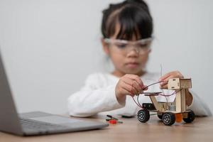 Asia students learn at home in coding robot cars and electronic board cables in STEM, STEAM, mathematics engineering science technology computer code in robotics for kids concept. photo