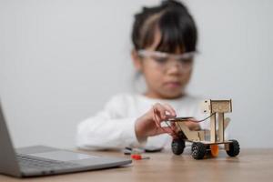 Asia students learn at home in coding robot cars and electronic board cables in STEM, STEAM, mathematics engineering science technology computer code in robotics for kids concept. photo