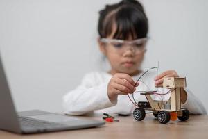 Asia students learn at home in coding robot cars and electronic board cables in STEM, STEAM, mathematics engineering science technology computer code in robotics for kids concept. photo