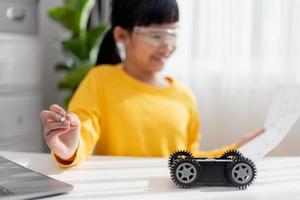 Asia students learn at home in coding robot cars and electronic board cables in STEM, STEAM, mathematics engineering science technology computer code in robotics for kids concept. photo