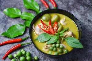 pollo al curry verde cocina comida asiática en la mesa - comida tailandesa curry verde en un tazón de sopa con ingredientes vegetales de hierbas sobre fondo de placa oscura foto