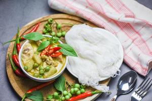 Thai food green curry chicken on soup bowl and thai rice noodles vermicelli with ingredient herb vegetable - asian food on the table photo