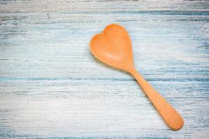 cuchara de madera sobre fondo de mesa de madera , vista superior - forma de corazón de cuchara de café , salud amorosa o concepto de cocina amorosa foto