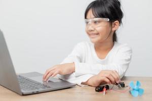 los estudiantes de asia aprenden en casa a codificar autos robot y cables de tableros electrónicos en tallo, vapor, ingeniería matemática, ciencia, tecnología, código de computadora en robótica para el concepto de niños. foto