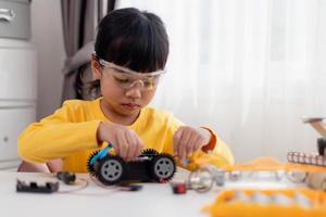 Asia students learn at home in coding robot cars and electronic board cables in STEM, STEAM, mathematics engineering science technology computer code in robotics for kids concept. photo