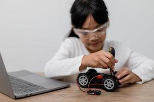 Asia students learn at home in coding robot cars and electronic board cables in STEM, STEAM, mathematics engineering science technology computer code in robotics for kids concept. photo