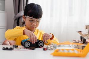 Asia students learn at home in coding robot cars and electronic board cables in STEM, STEAM, mathematics engineering science technology computer code in robotics for kids concept. photo