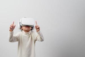 niña asiática con casco de realidad virtual. concepto de educación y tecnología de innovación foto