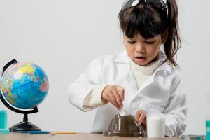 education, science, chemistry and children concept - kids or students with test tube making experiment at school laboratory photo