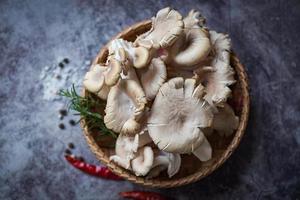 Grey oyster mushroom on basket , fresh raw oyster mushroom with herbs and spices for cooking food photo