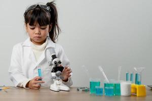 concepto de educación, ciencia, química y niños - niños o estudiantes con tubos de ensayo haciendo experimentos en el laboratorio escolar foto