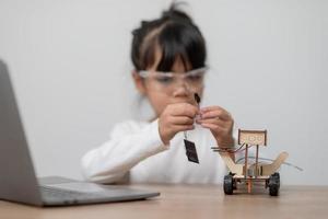 Asia students learn at home in coding robot cars and electronic board cables in STEM, STEAM, mathematics engineering science technology computer code in robotics for kids concept. photo