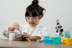 education, science, chemistry and children concept - kids or students with test tube making experiment at school laboratory photo