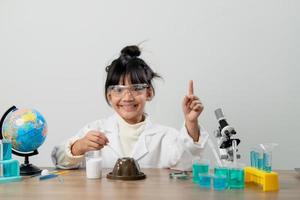 education, science, chemistry and children concept - kids or students with test tube making experiment at school laboratory photo