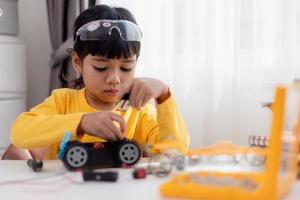 Asia students learn at home in coding robot cars and electronic board cables in STEM, STEAM, mathematics engineering science technology computer code in robotics for kids concept. photo