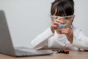 Asia students learn at home in coding robot cars and electronic board cables in STEM, STEAM, mathematics engineering science technology computer code in robotics for kids concept. photo