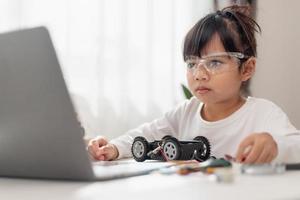 Asia students learn at home in coding robot cars and electronic board cables in STEM, STEAM, mathematics engineering science technology computer code in robotics for kids concept. photo