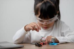 Asia students learn at home in coding robot cars and electronic board cables in STEM, STEAM, mathematics engineering science technology computer code in robotics for kids concept. photo