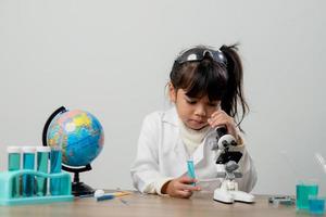 concepto de educación, ciencia, química y niños - niños o estudiantes con tubos de ensayo haciendo experimentos en el laboratorio escolar foto