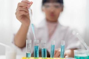 education, science, chemistry and children concept - kids or students with test tube making experiment at school laboratory photo