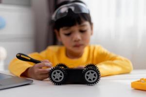 los estudiantes de asia aprenden en casa a codificar autos robot y cables de tableros electrónicos en tallo, vapor, ingeniería matemática, ciencia, tecnología, código de computadora en robótica para el concepto de niños. foto