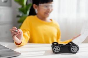 Asia students learn at home in coding robot cars and electronic board cables in STEM, STEAM, mathematics engineering science technology computer code in robotics for kids concept. photo