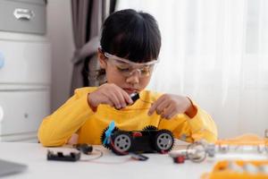Asia students learn at home in coding robot cars and electronic board cables in STEM, STEAM, mathematics engineering science technology computer code in robotics for kids concept. photo