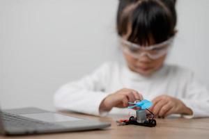 Asia students learn at home in coding robot cars and electronic board cables in STEM, STEAM, mathematics engineering science technology computer code in robotics for kids concept. photo