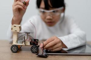 Asia students learn at home in coding robot cars and electronic board cables in STEM, STEAM, mathematics engineering science technology computer code in robotics for kids concept. photo