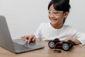 Asia students learn at home in coding robot cars and electronic board cables in STEM, STEAM, mathematics engineering science technology computer code in robotics for kids concept. photo