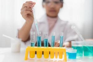 education, science, chemistry and children concept - kids or students with test tube making experiment at school laboratory photo