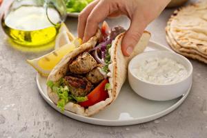 Chicken souvlaki with fresh vegetables on a flatbread photo