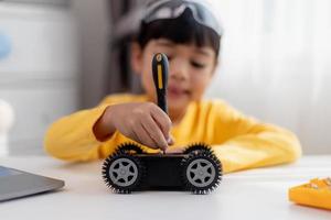 Asia students learn at home in coding robot cars and electronic board cables in STEM, STEAM, mathematics engineering science technology computer code in robotics for kids concept. photo