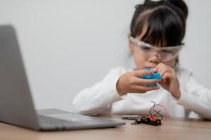 Asia students learn at home in coding robot cars and electronic board cables in STEM, STEAM, mathematics engineering science technology computer code in robotics for kids concept. photo