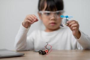 Asia students learn at home in coding robot cars and electronic board cables in STEM, STEAM, mathematics engineering science technology computer code in robotics for kids concept. photo