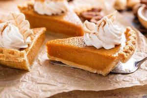 Festive pumpkin pie slices decorated with whipped cream photo