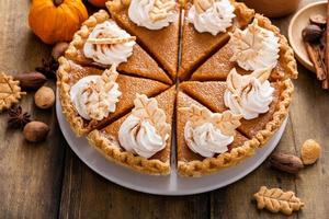 Traditional Thanksgiving pumpkin pie cut into slices photo