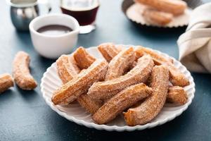 churros caseros con azúcar de canela en un plato foto