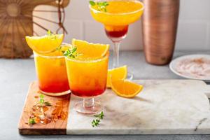 Tequila sunrise cocktails in a variety of glasses photo