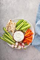 tabla de bocadillos grande con dip o salsa tzatziki y verduras frescas foto