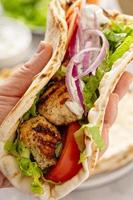 Chicken souvlaki with fresh vegetables on a flatbread photo