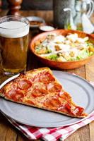 Pepperoni pizza slice with a side salad photo