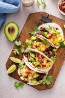 Breakfast tacos with sausage, eggs, bacon and avocado photo